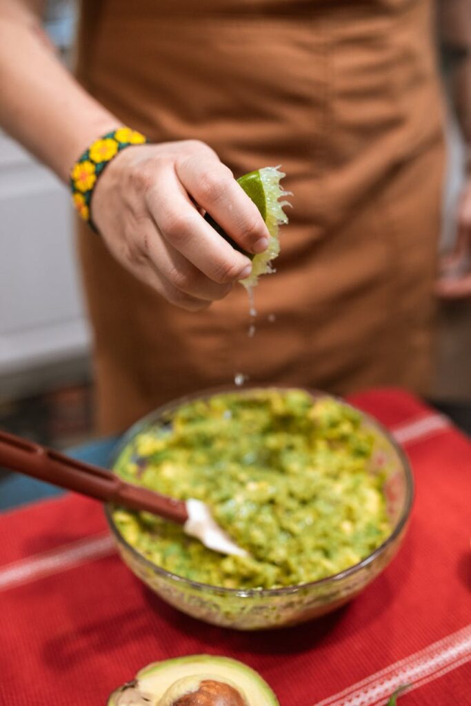 a person putting lime in the guacamole