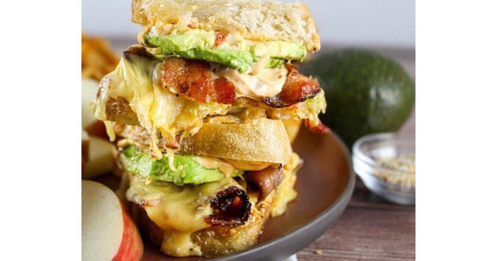 Stacked bacon, avocado and turkey sandwich on sourdough bread.