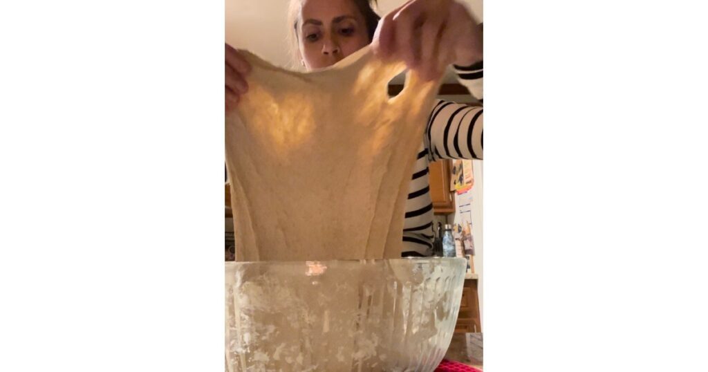 Person stretching bread dough