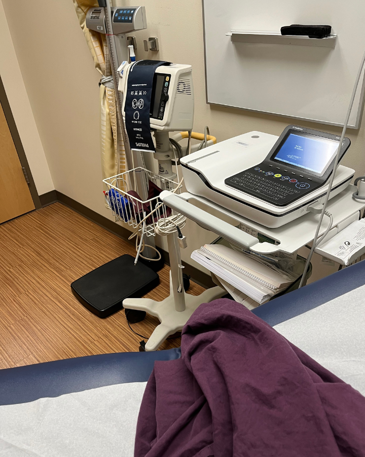 Purple gown on a medical table next to medical EKG Equipment.