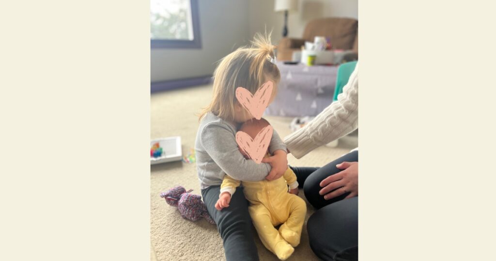 toddler holding newborn baby