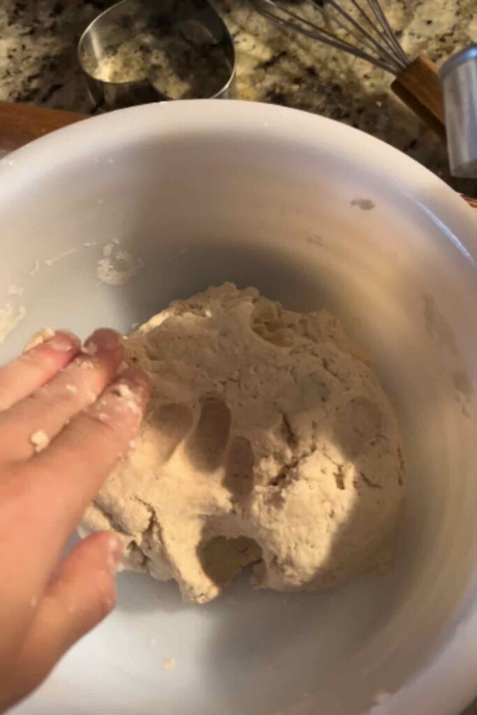 Hand pressing dough ball.