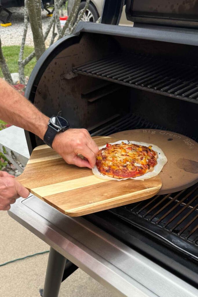 pizza being removed from traeger on pizza peel.