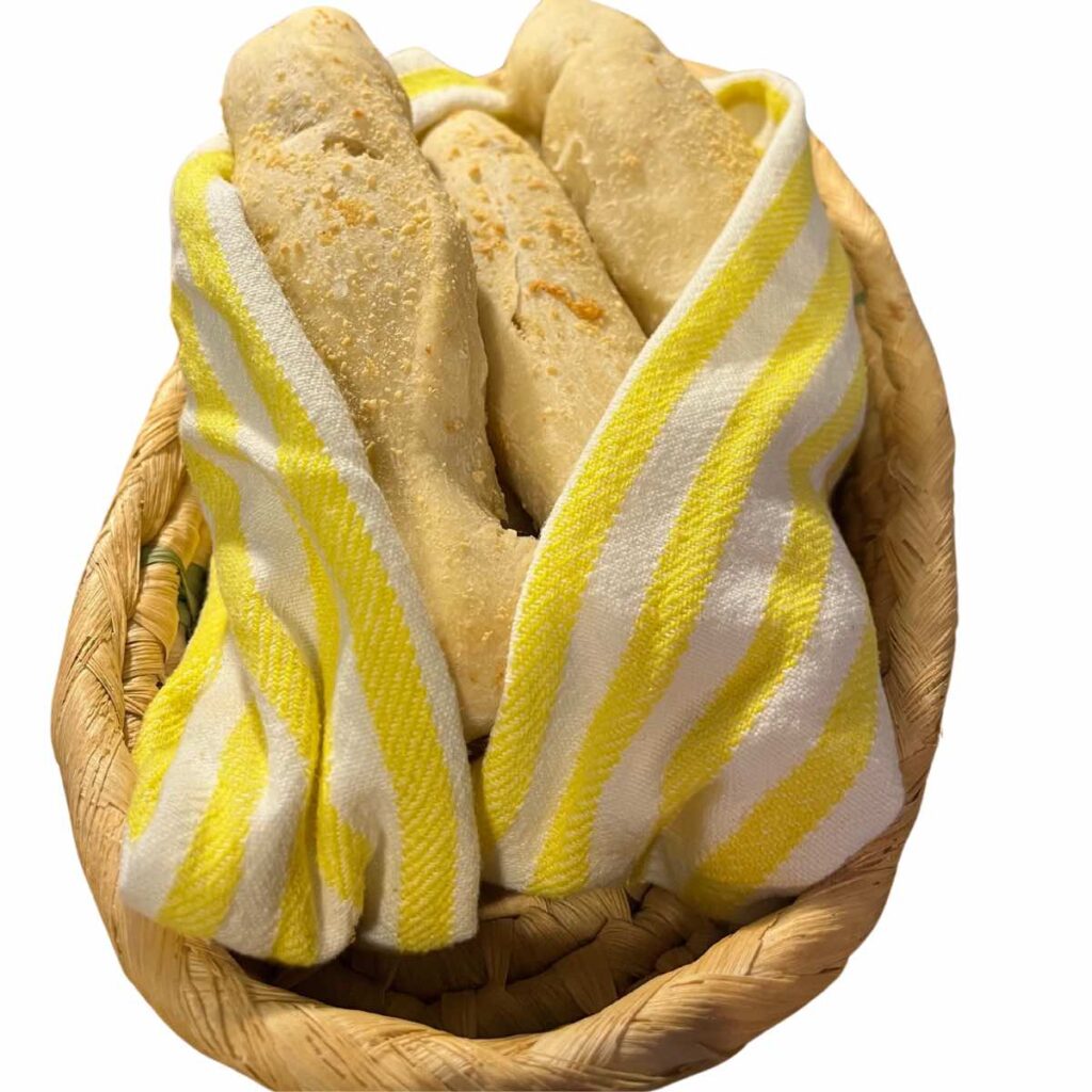 sourdough discard breadsticks in towel and basket.