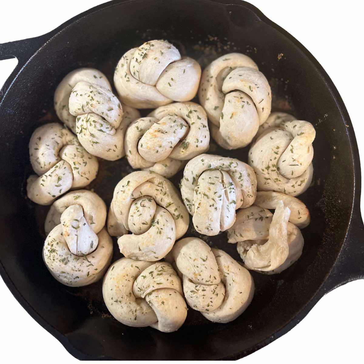 sourdough garlic knots in a cast iron skillet.