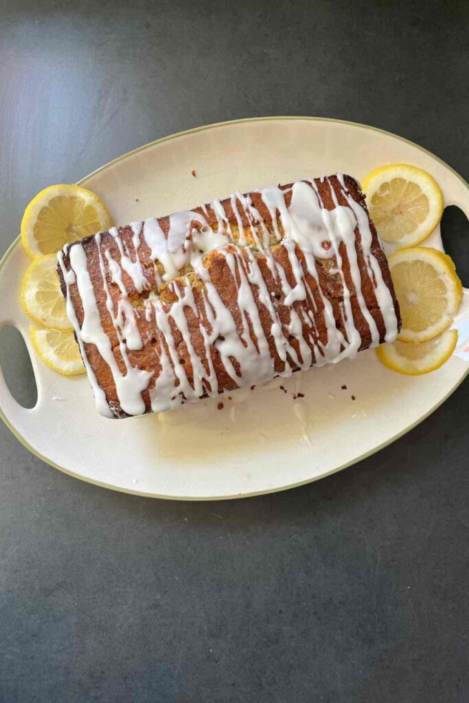 sourdough lemon poppyseed loaf with glaze and lemon slices.