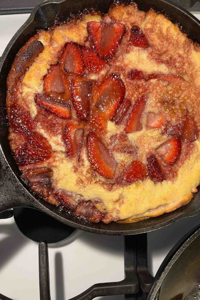 baked strawberries in strawberry dutch baby in cast iron skillet
