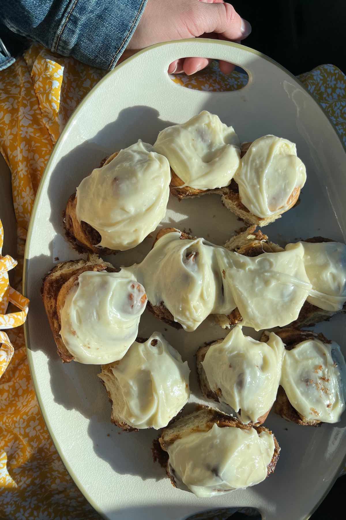 frosted sourdough cinnamon rolls on plate.