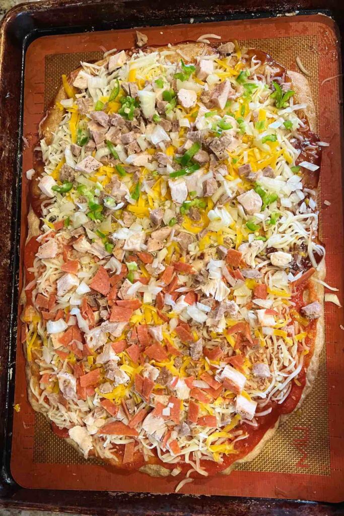 sourdough pizza crust on a sheet pan before baking.
