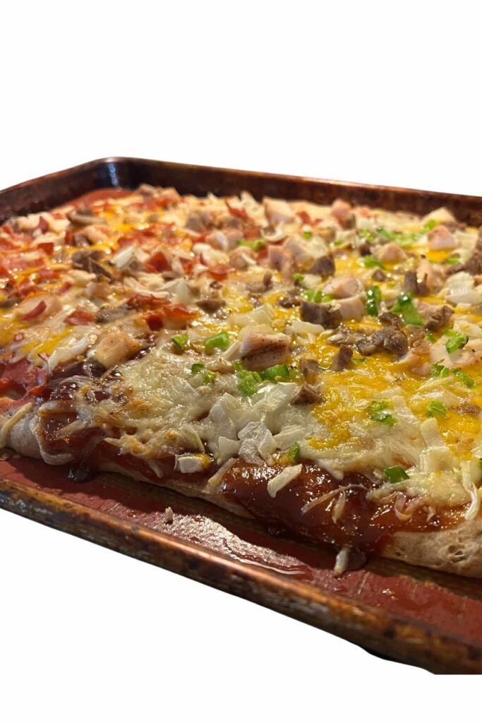 sheet pan pizza with different toppings on each half.