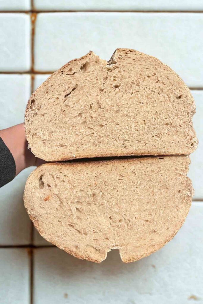 loaf of sourdough bread with white marble behind it.