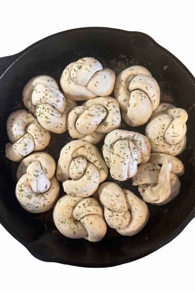sourdough garlic knots in a cast iron skillet.
