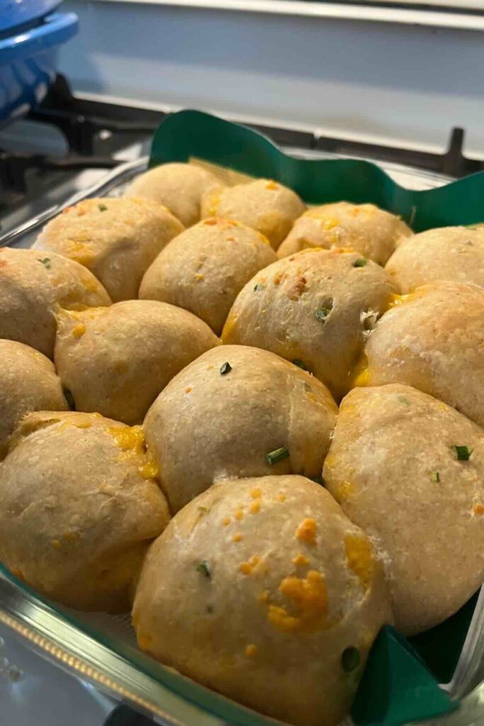 baked sourdough cheddar rolls on a stovetop.