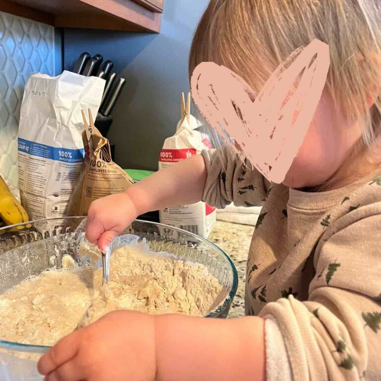 child stirring sourdough in bowl.