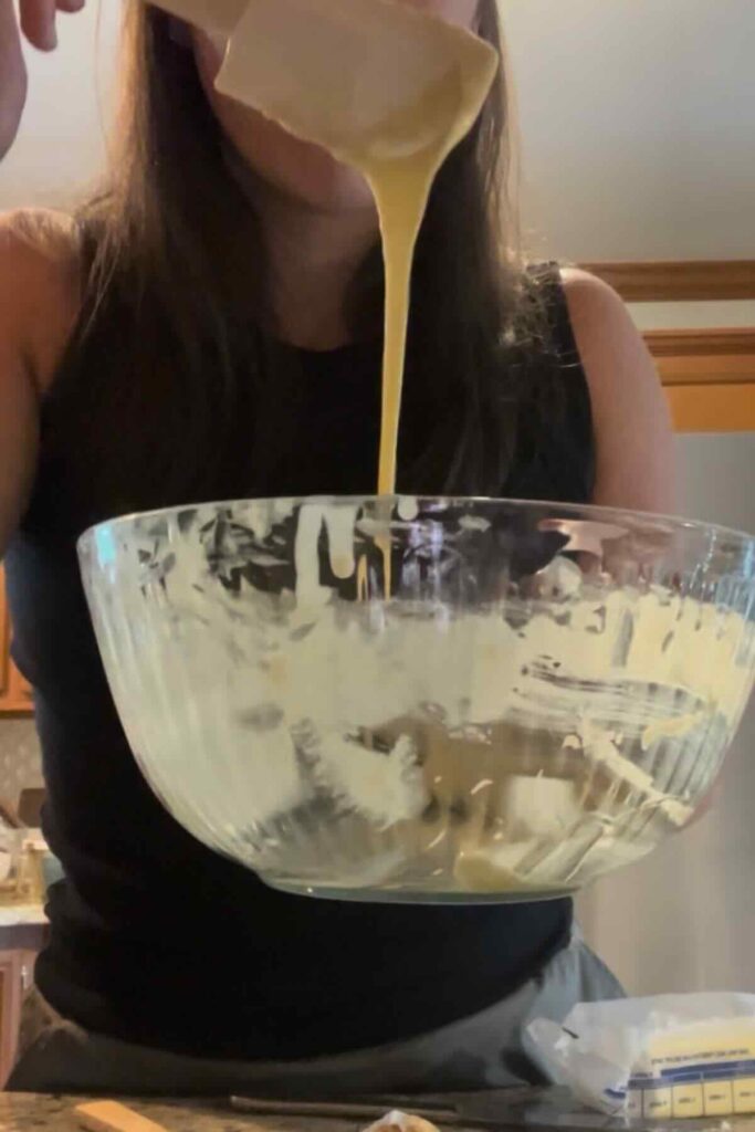 spatula with waffle batter over glass bowl.
