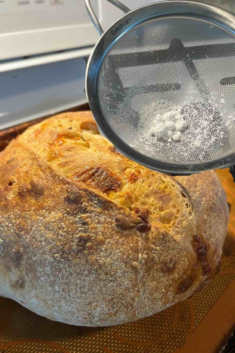 dusting flour in front of sourdough bread.