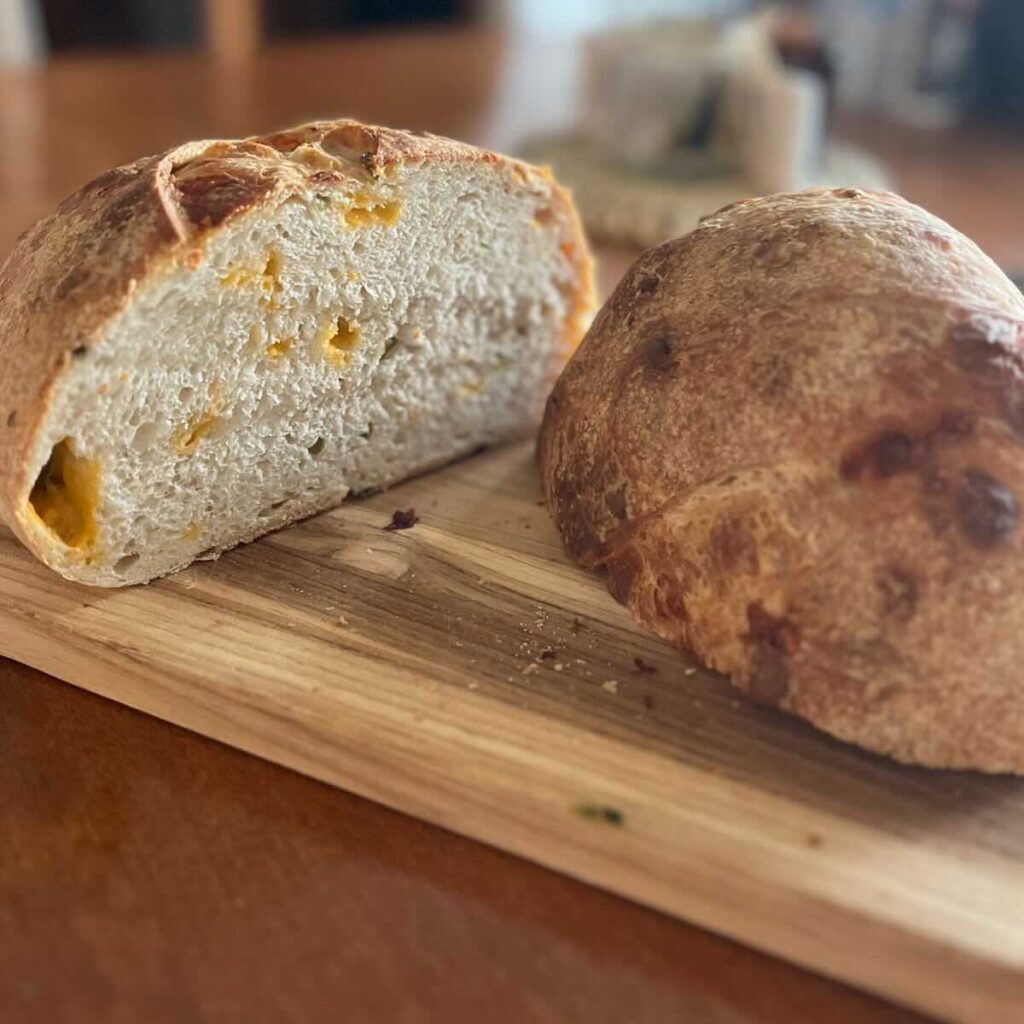 sourdough bread sliced in half on a wooden cutting board.