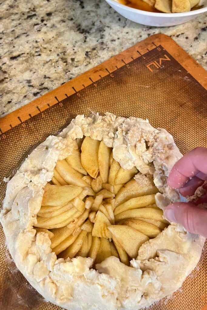 sprinkling sugar on sourdough apple galette