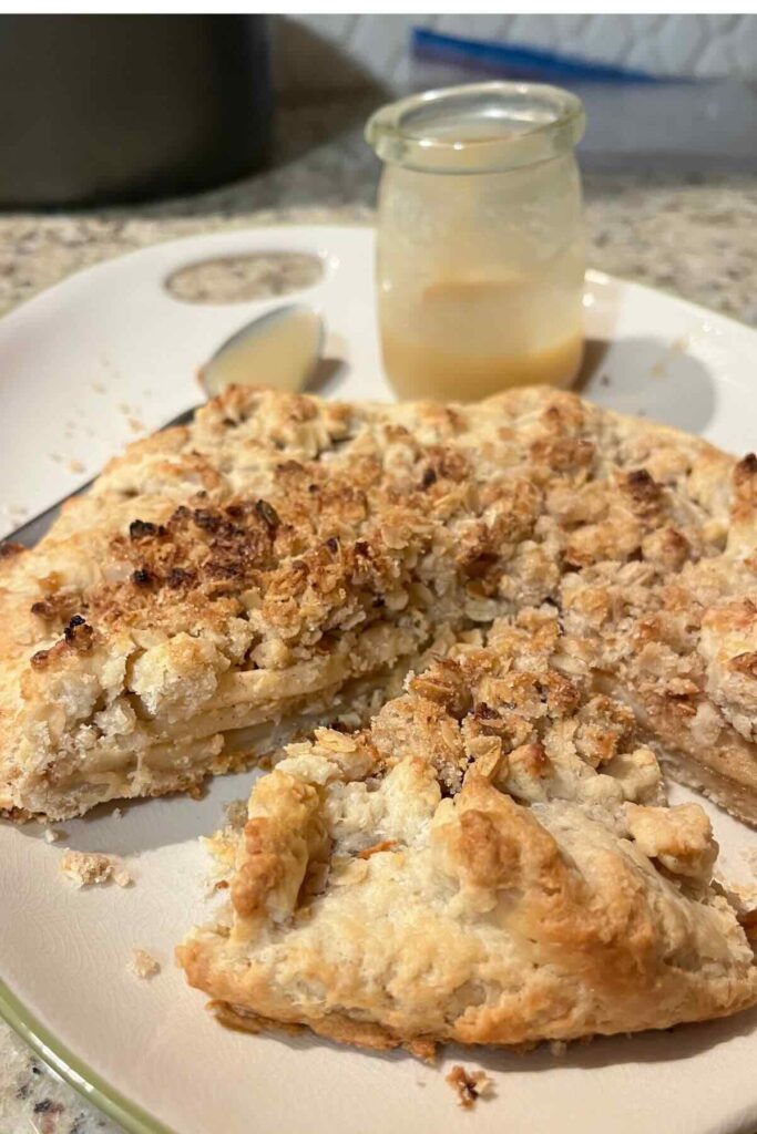 slice of sourdough apple pie galette with caramel behind it