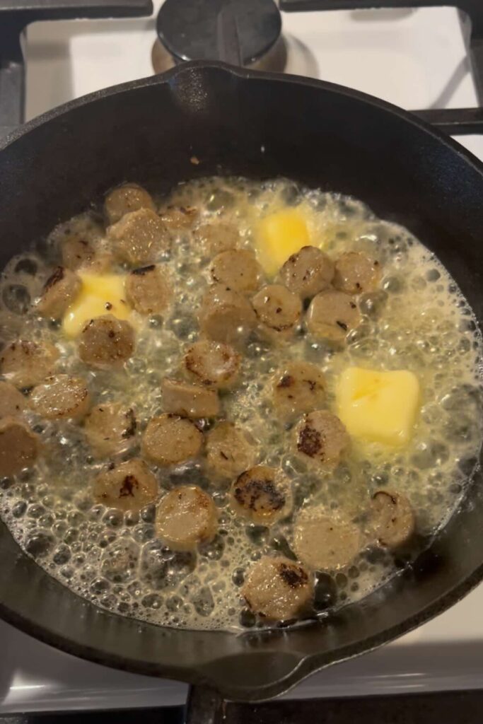 browning sausage with butter in a cast iron skillet.