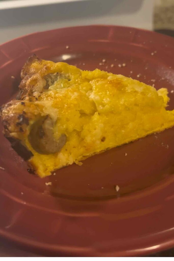 slice of savory sourdough dutch baby on red plate.