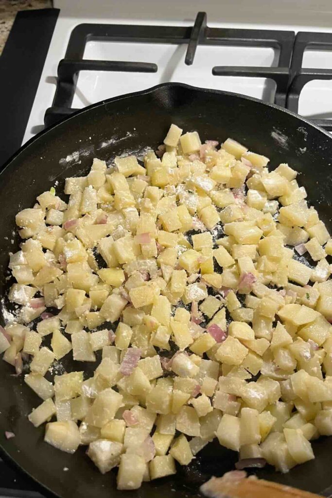 diced potato and onions in cast iron skillet.