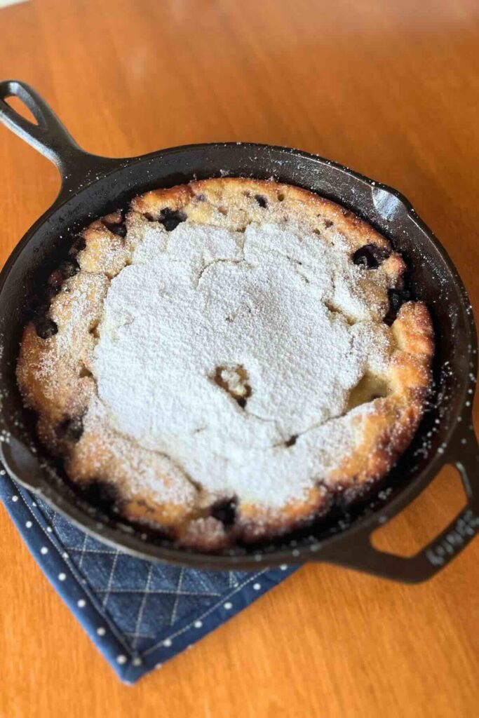 lemon blueberry sourdough dutch baby in a cast iron skillet.