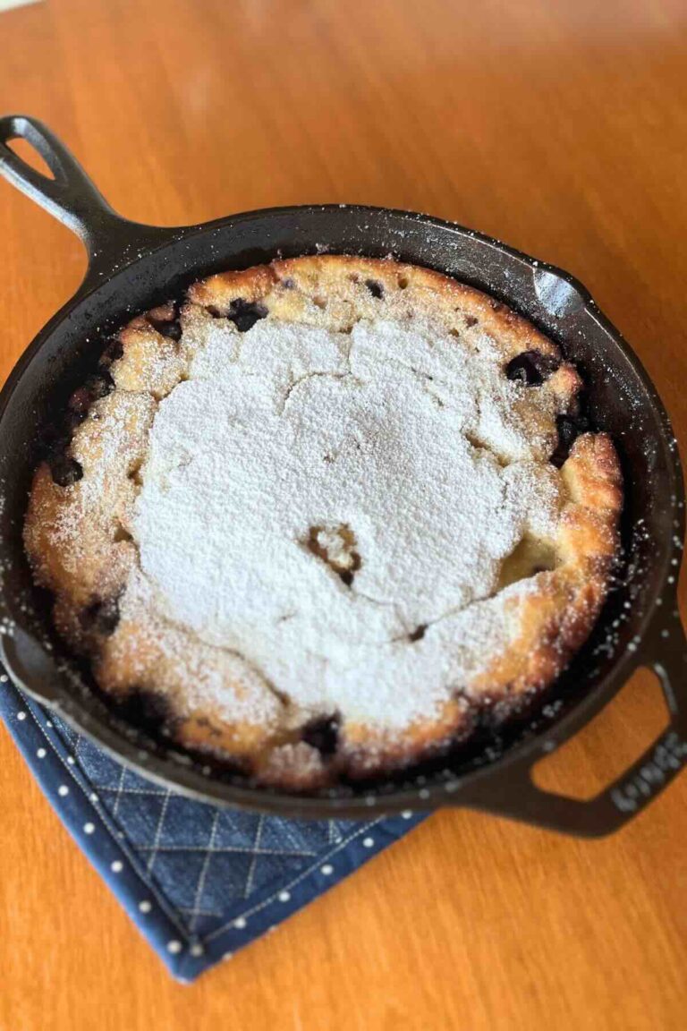 lemon blueberry sourdough dutch baby in a cast iron skillet.