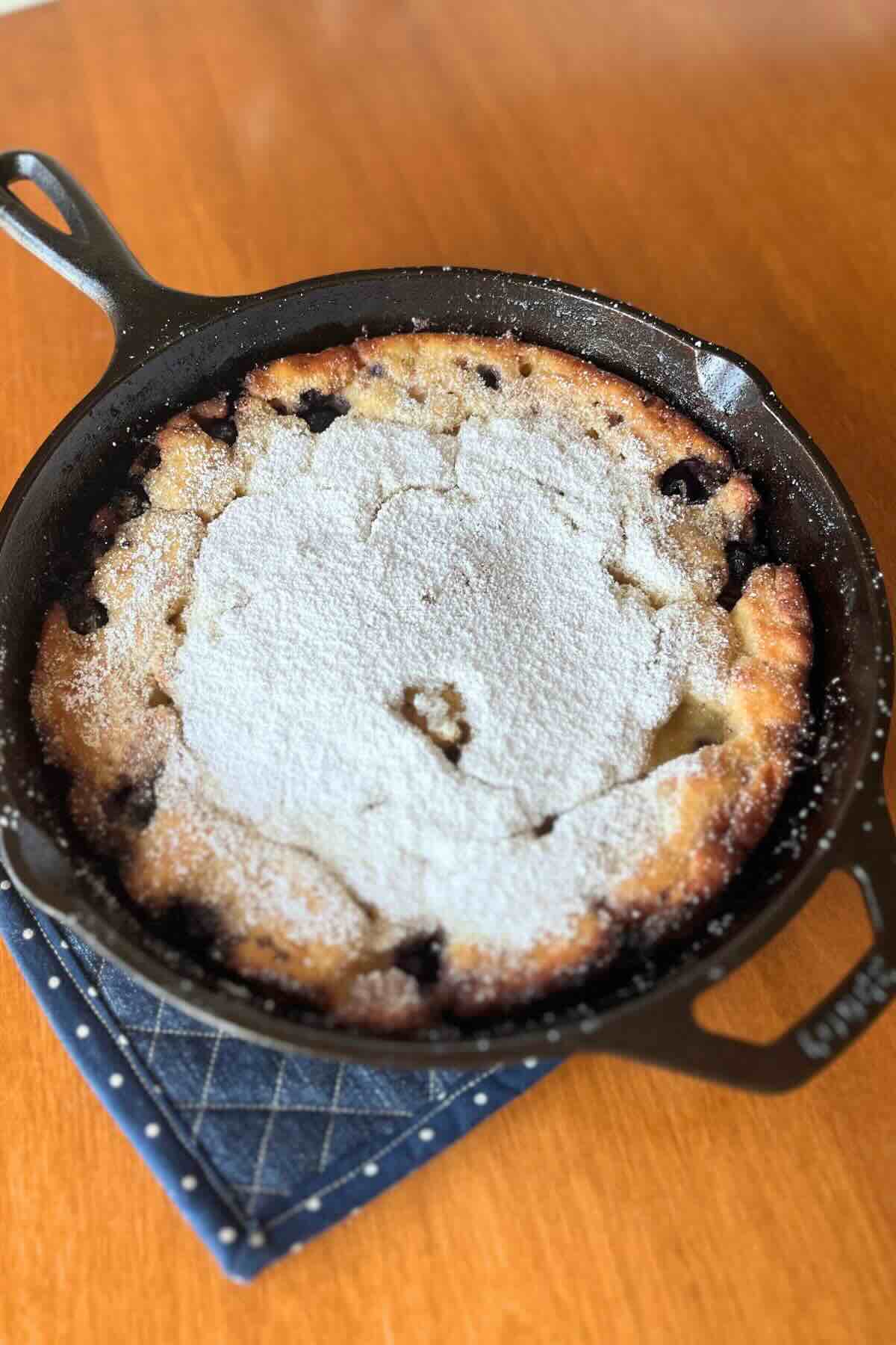 lemon blueberry sourdough dutch baby in a cast iron skillet.