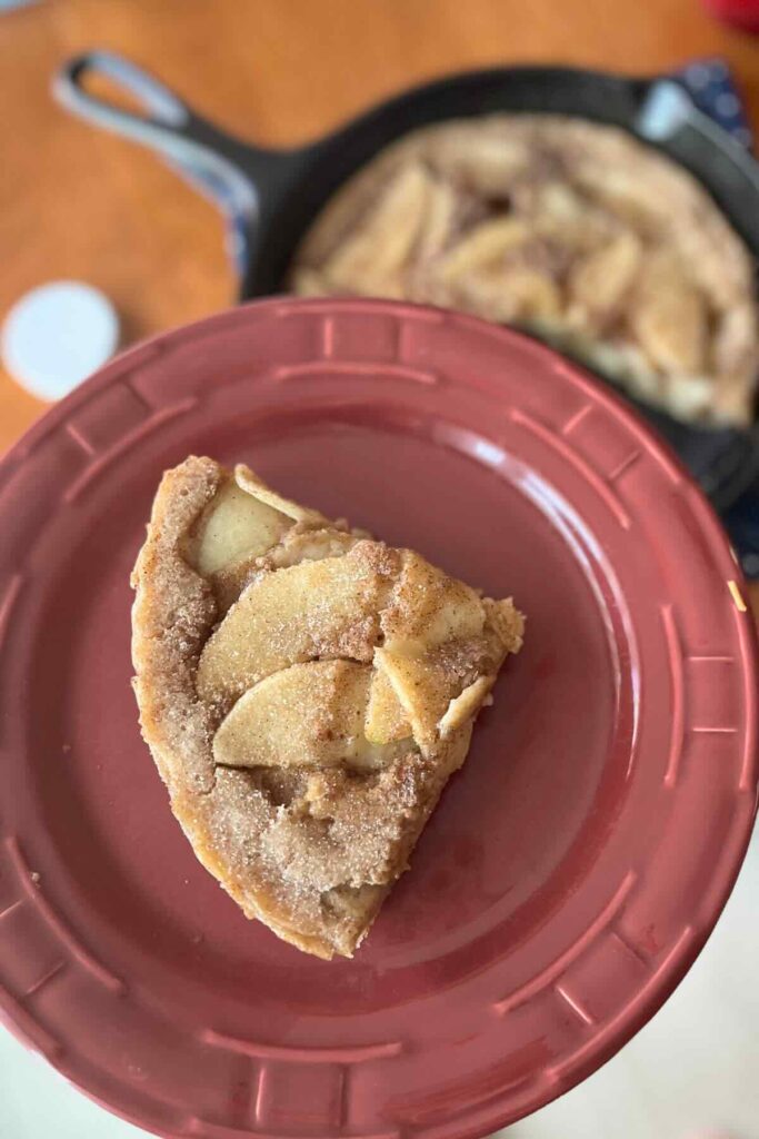 apple sourdough dutch baby on a red plate.