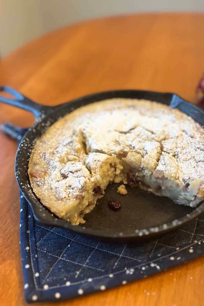 cranberry walnut sourdough dutch baby in a cast iron skillet.