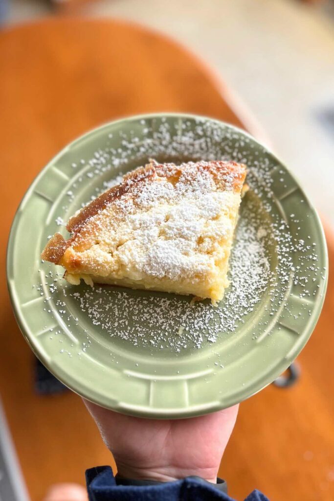sourdough dutch baby with powdered sugar on a green plate.