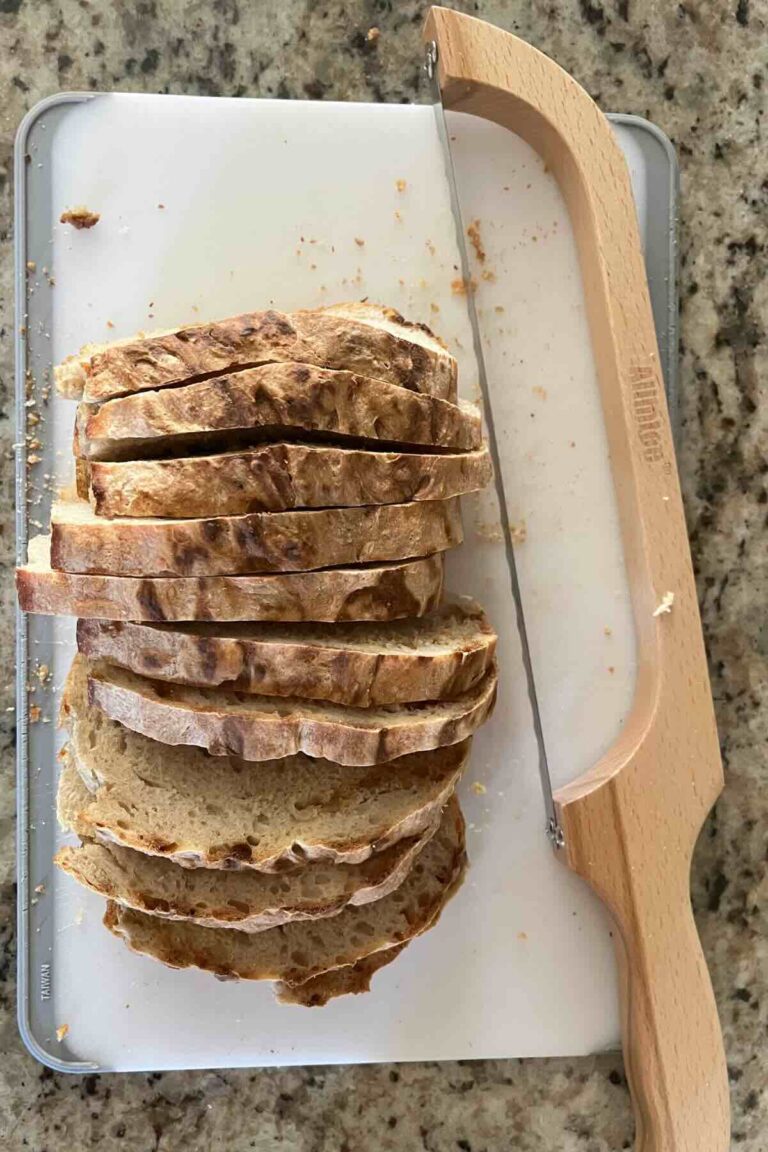 sliced sourdough bread next to sourdough bread knife.