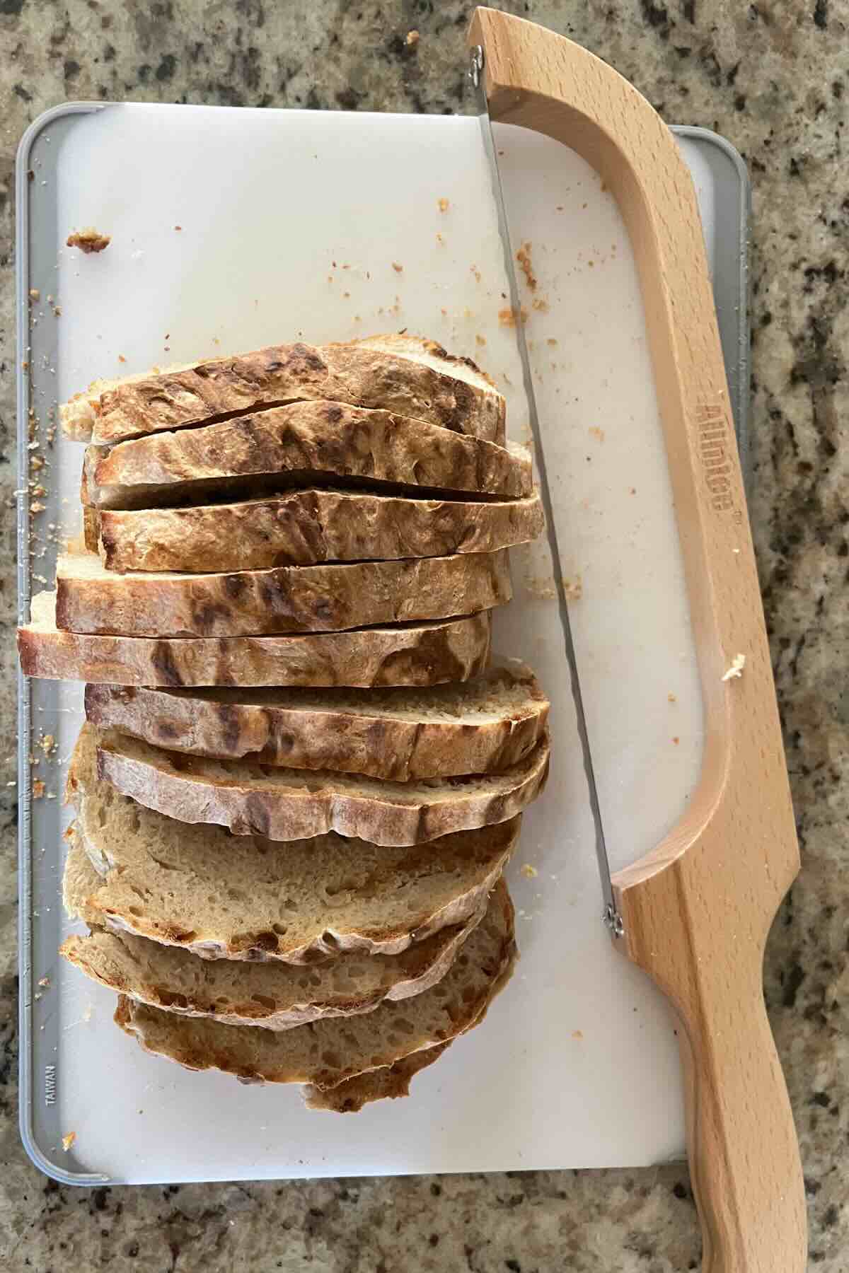 sliced sourdough bread next to sourdough bread knife.