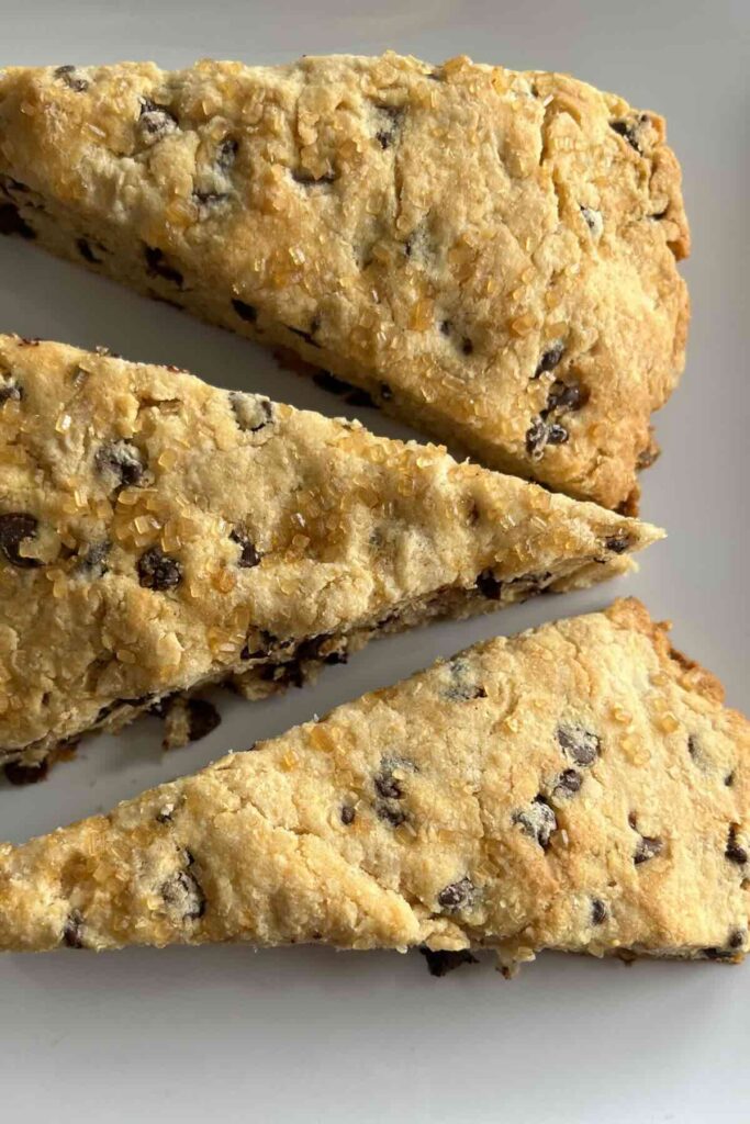 three whole wheat chocolate chip scones on a plate.
