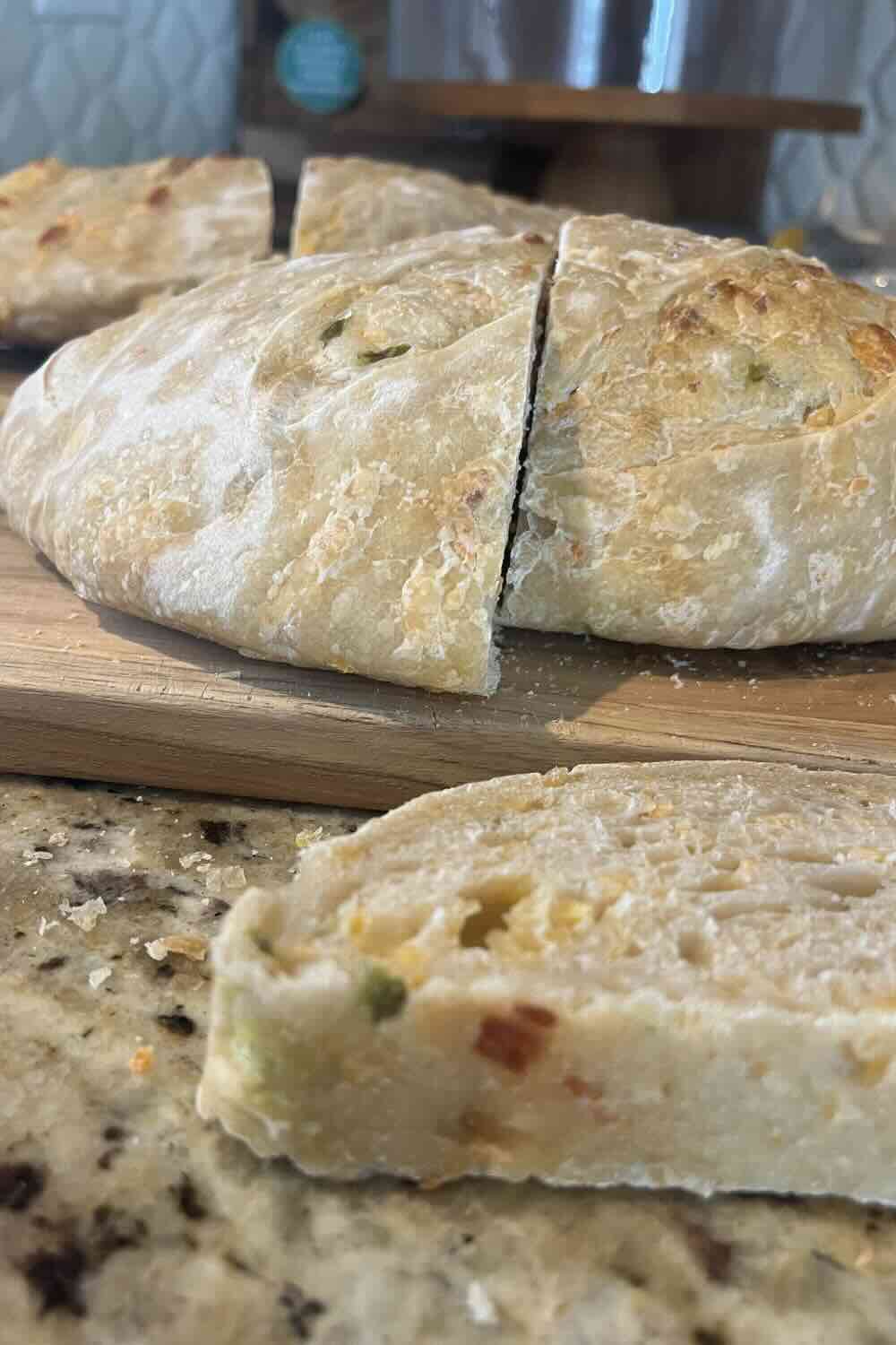 flat loaf of sourdough bread on a cutting board.